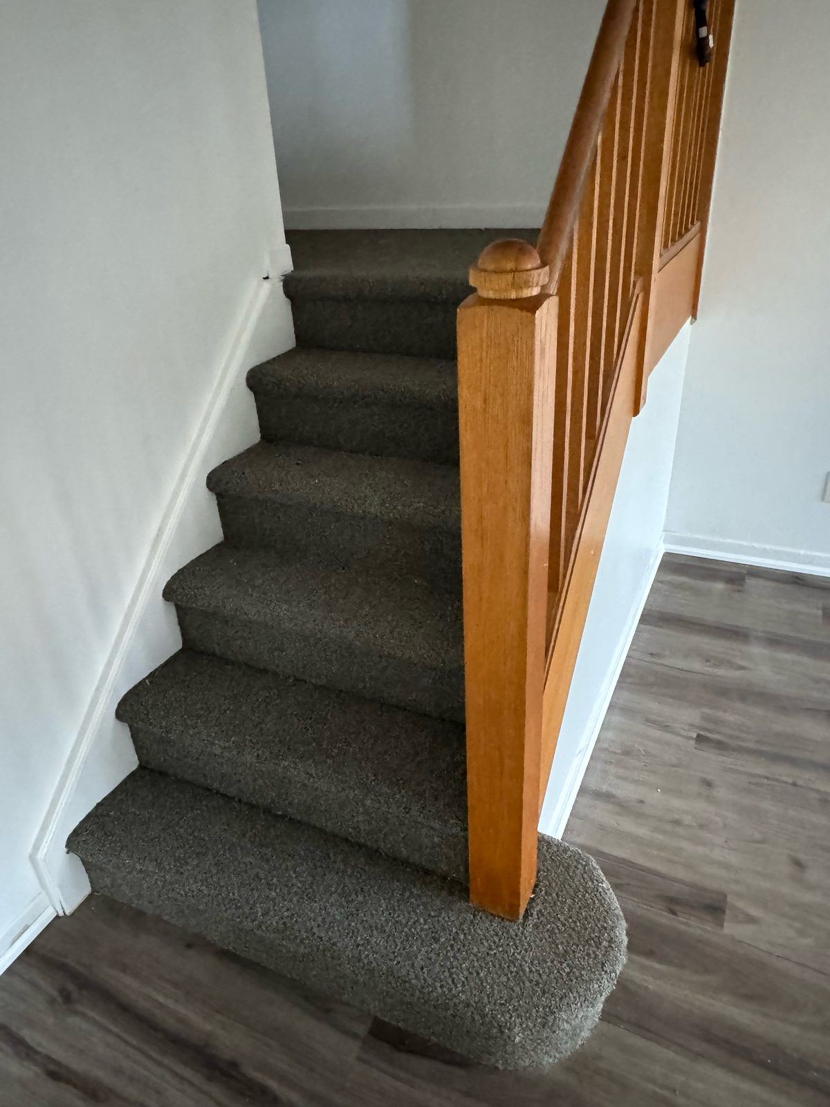 Carpeted stairs with rounded bottom step